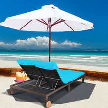 Load image into Gallery viewer, Beach scene with two blue lounge chairs and a large white umbrella on a sandy area near the ocean.
