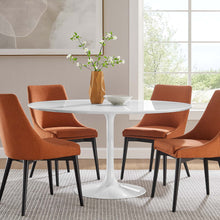 Load image into Gallery viewer, Dining room with a white round table and orange chairs near a window.

